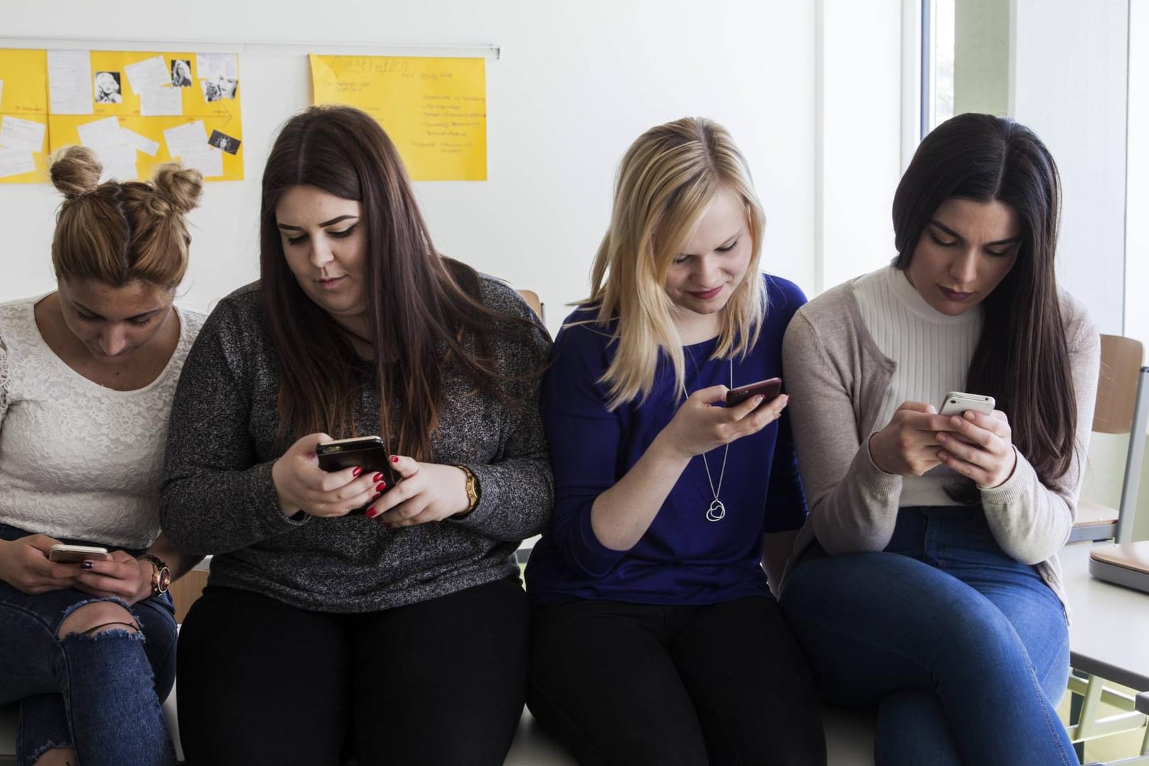 Schülerinnen schauen auf ihre Smartphones: 47 Prozent der Jugendlichen nutzen die Youtube-App zu lernen.