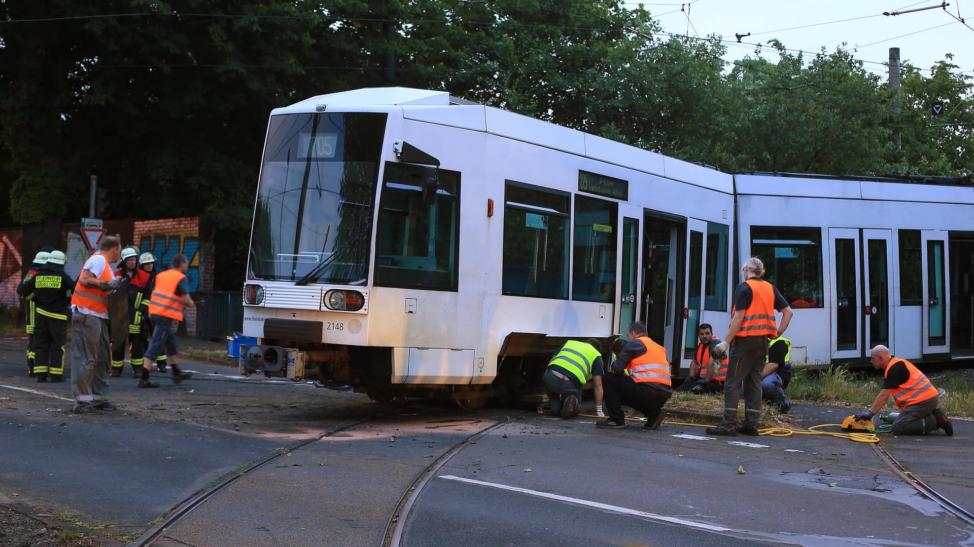 Strassenbahnunfall in Düsseldorf: Feuerwehrleute und Mitarbeiter der Rheinbahn arbeiten an einer entgleisten Strassenbahn, um sie wieder zurück auf die Gleise zu setzen.