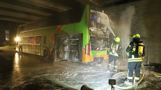 Feuerwehrleute löschen einen Reisebus. Feuerwehrleute löschen einen Reisebus.