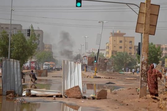 Rauch steigt in Khartum hinter einer Straßenbarrikade auf, die Militärfahrzeuge am Durchkommen hindern soll.