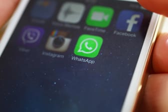 Eine Nutzerin hält ein Smartphone, auf dem WhatsApp installiert ist: Der Messenger will offenbar jedem Nutzer einen QR-Code zuordnen.