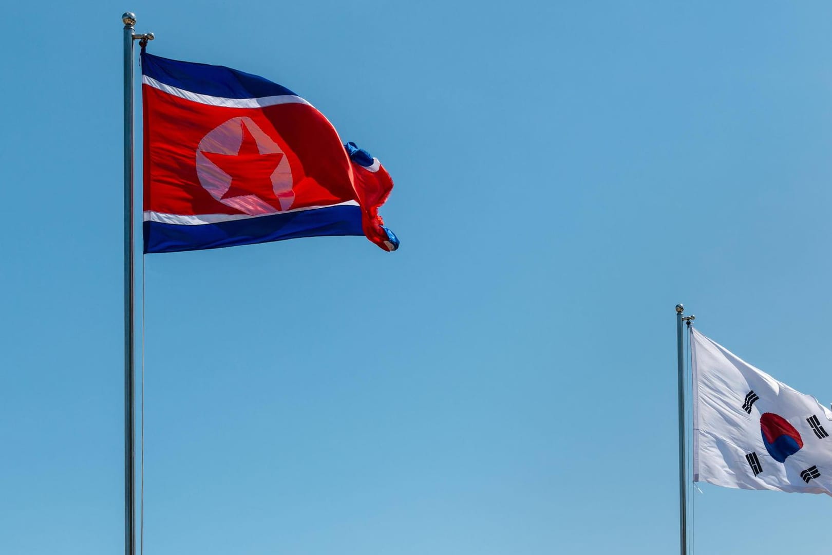Nordkoreanische und südkoreanische Flagge: In Nordkorea haben viele Völker nicht genügend Lebensmittel.