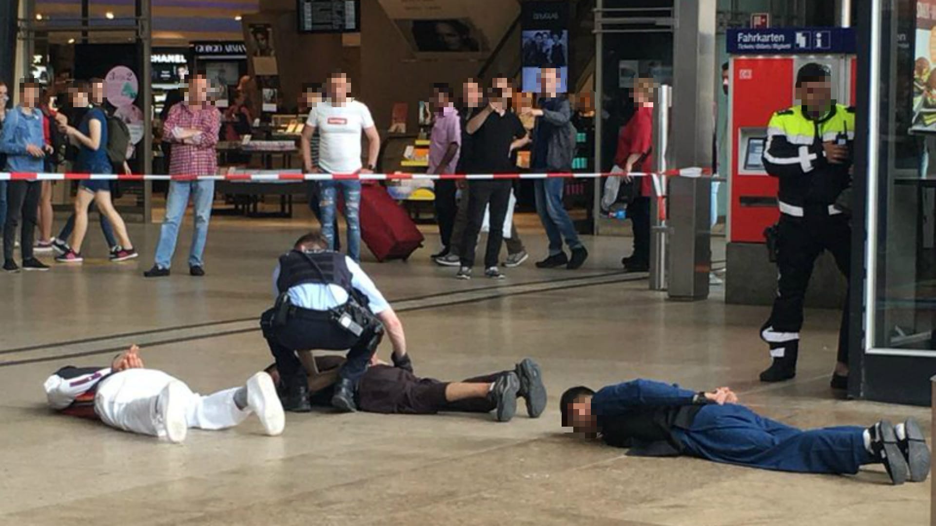 Kölner Hauptbahnhof am Dienstag: Mit verbundenen Händen und den Gesichtern nach unten liegen mehrere junge Männer in muslimischen Gewändern am Boden, während ein Polizist sie kontrolliert.