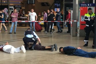 Kölner Hauptbahnhof am Dienstag: Mit verbundenen Händen und den Gesichtern nach unten liegen mehrere junge Männer in muslimischen Gewändern am Boden, während ein Polizist sie kontrolliert.
