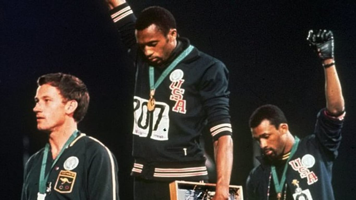 Tommie Smith (M) und John Carlos strecken 1968 bei der Siegerehrung die Fäuste nach oben.