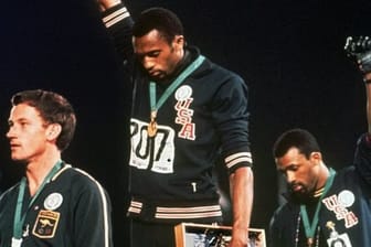 Tommie Smith (M) und John Carlos strecken 1968 bei der Siegerehrung die Fäuste nach oben.