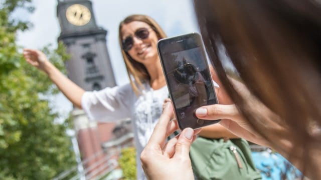 Frau fotografiert eine Freundin vor einer Sehenswürdigkeit: Bevor man solche Fotos in Sozialen Medien teilt, sollte man die Freundin um Erlaubnis fragen.