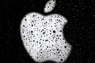 Das Apple-Logo ist hinter einer verregneten Scheibe zu sehen: App-Entwickler wehren sich gegen die Konditionen im Apple App Store.
