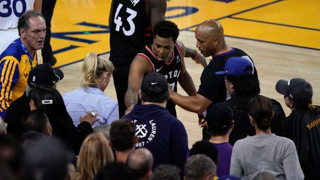 Kyle Lowry (M) von den Toronto Raptors beschwert sich neben Schiedsrichter Marc Davis über einen Fan.