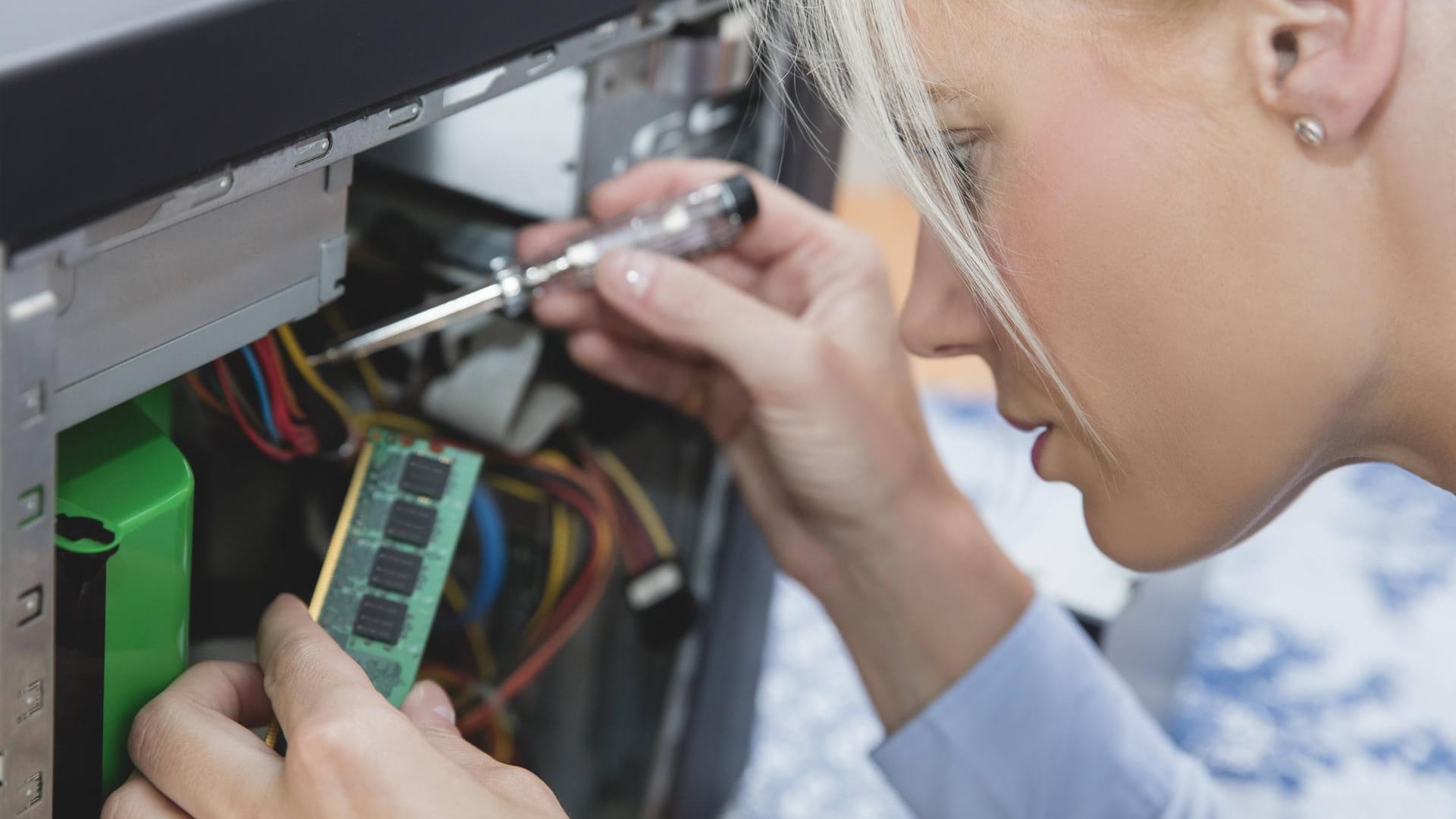 Eine Frau baut einem RAM-Riegel in einen PC ein: Alte Geräte müssen nicht gleich auf dem Schrott landen.