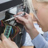Eine Frau baut einem RAM-Riegel in einen PC ein: Alte Geräte müssen nicht gleich auf dem Schrott landen.