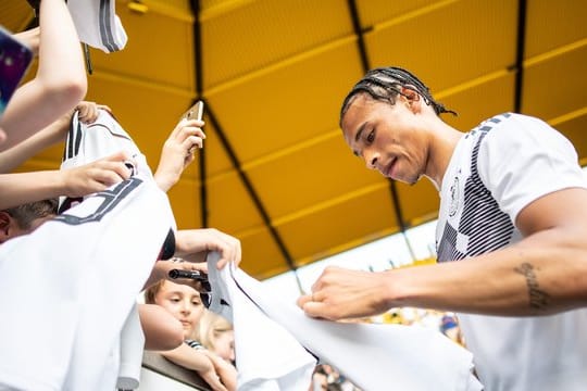 Nach einer öffentlichen Trainingseinheit gibt Leroy Sané in Aachen Autogramme.