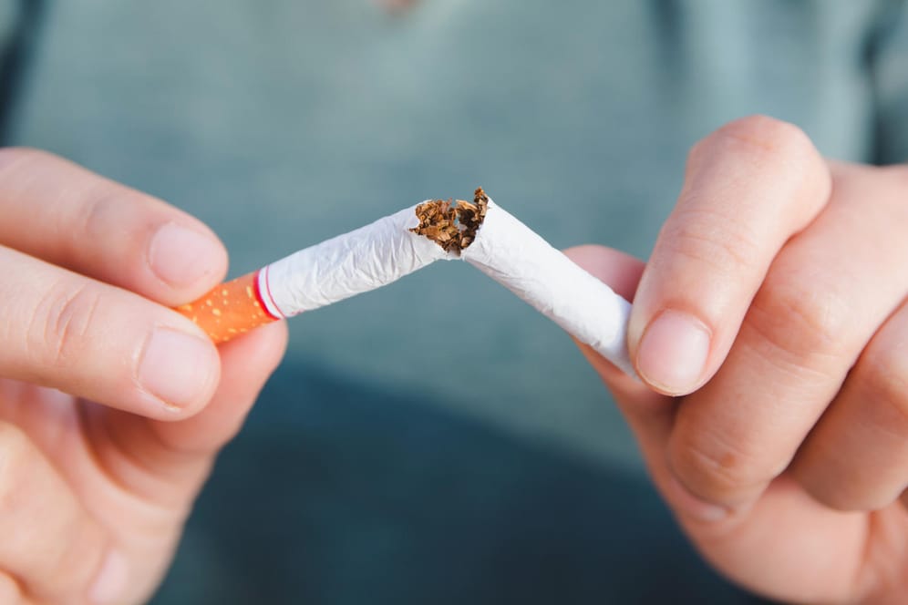 Frau zerknickt Zigarette: Rauchen schadet der Gesundheit.