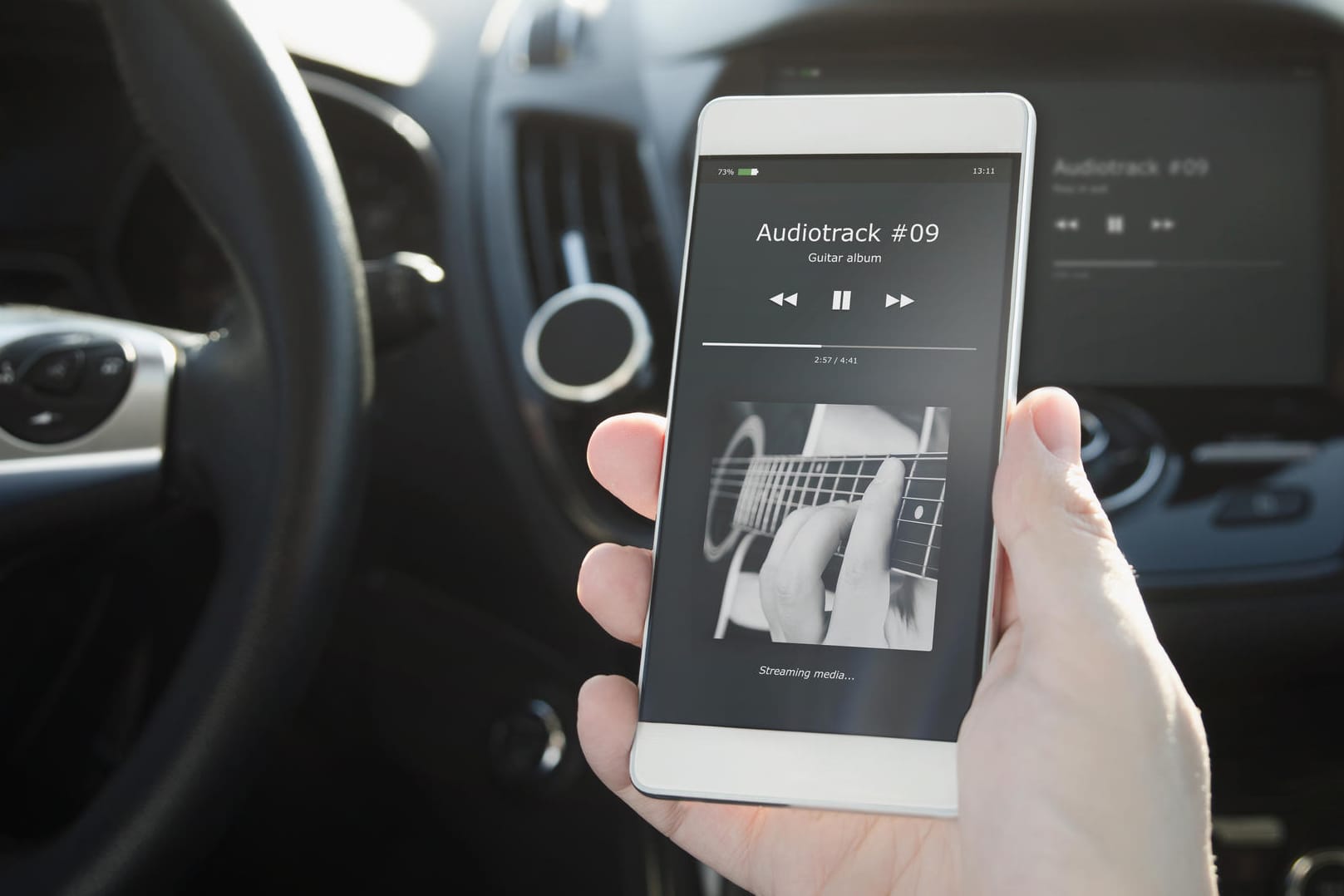 Ein Smartphone im Auto: Mit einem FM-Transmitter übertragen Sie Musik zum Autoradio.