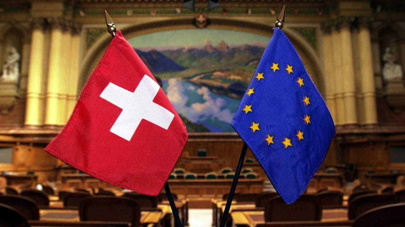 Schweizer und EU Flagge: Die Schweizer Regierung will das Abkommen mit der EU erst einmal nicht unterschreiben.