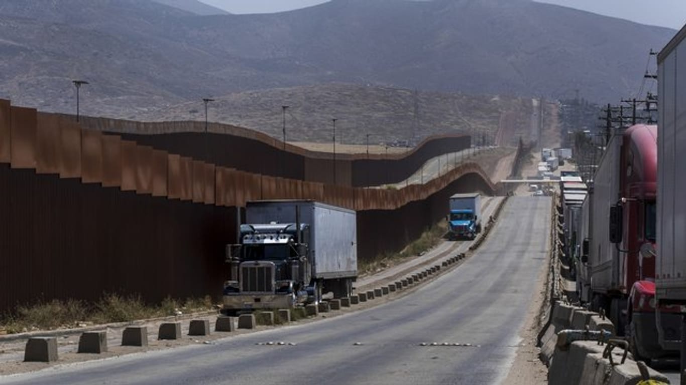 Lastwagen an einem Grenzzaun in Tijuana.