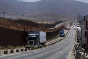 Lastwagen an einem Grenzzaun in Tijuana.