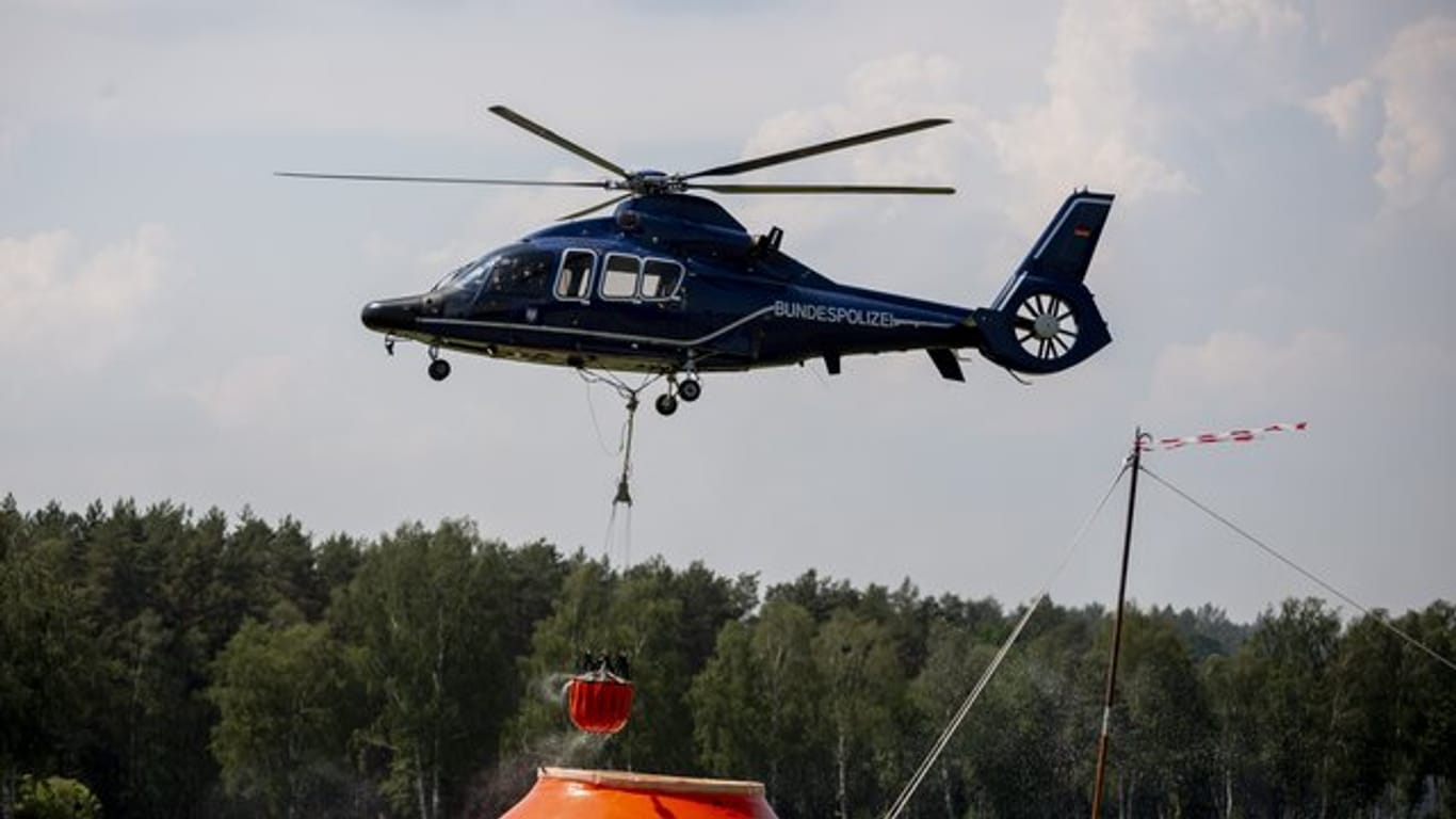 Ein Hubschrauber der Bundespolizei nimmt in Frankenförde Löschwasser auf.