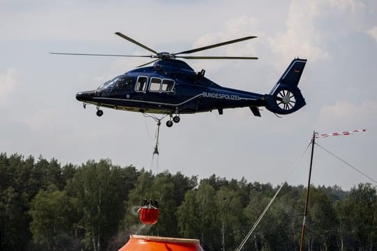 Ein Hubschrauber der Bundespolizei nimmt in Frankenförde Löschwasser auf.