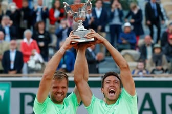 Kevin Krawietz (l) und Andreas Mies jubeln nach dem Turniersieg mit dem Pokal.