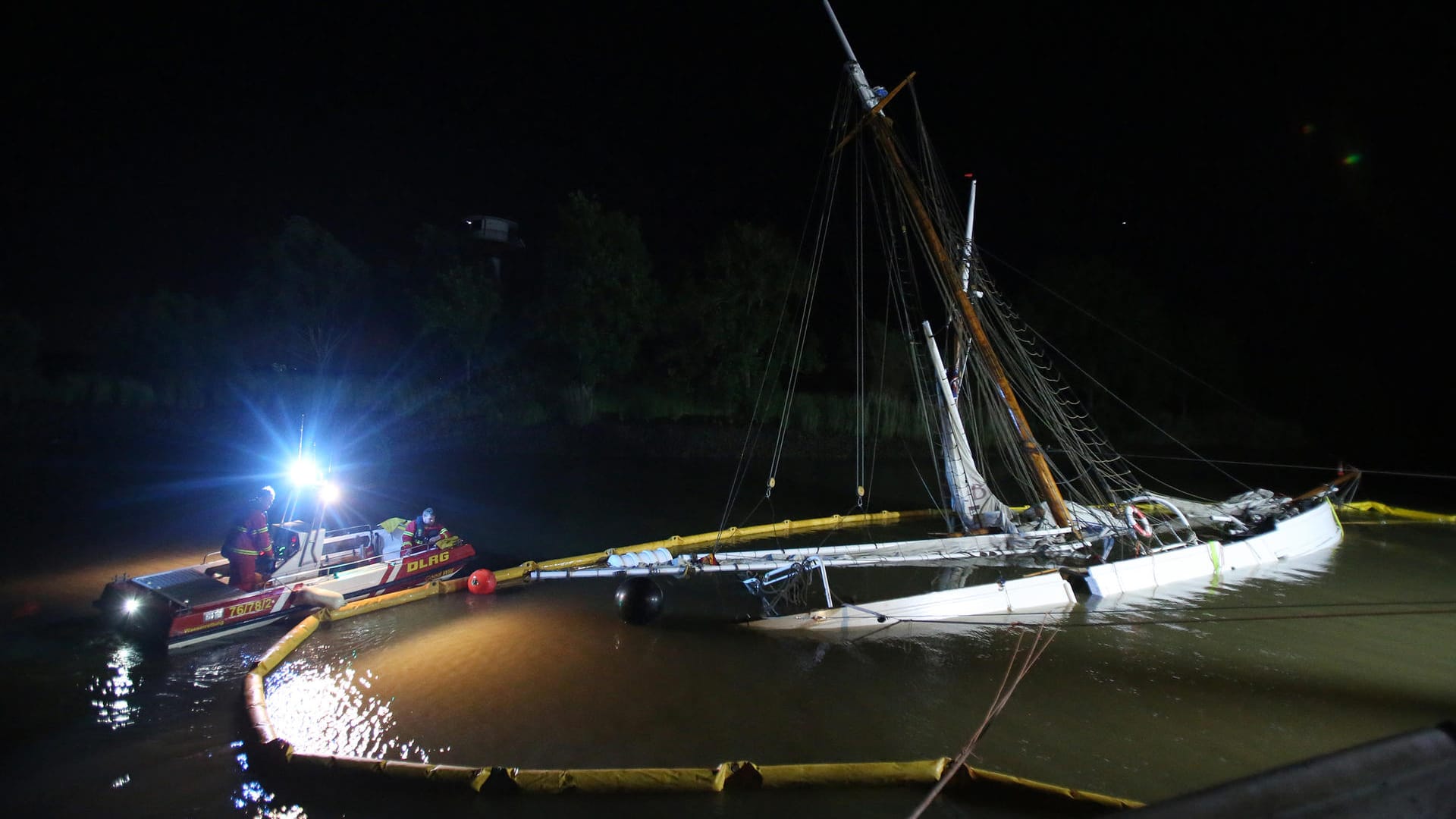 DLRG-Mitarbeiter sichten die Ölsperren am Wrack: Das erst jüngst aufwendig sanierte historische Segelschiff ist auf der Elbe mit einem Containerschiff kollidiert und gesunken.