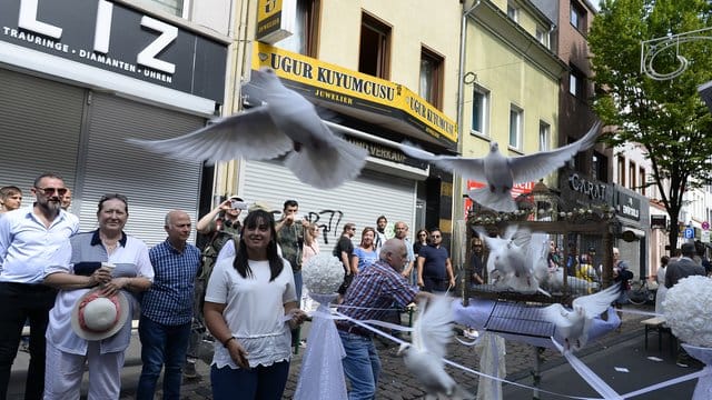 Teilnehmer einer Schweigeminute lassen auf der Kölner Keupstrasse am 15.