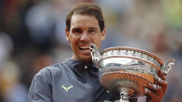 Rafael Nadal beißt nach seinem Sieg in die Trophäe.