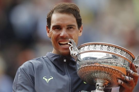 Rafael Nadal beißt nach seinem Sieg in die Trophäe.