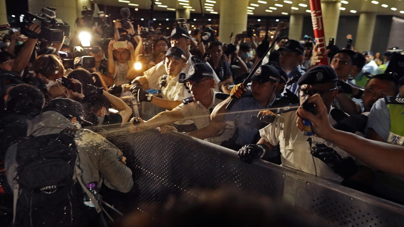 Umringt von Kameras verteidigen Polizisten die Absperrungen: Die Atmosphäre in Hongkong ist angespannt.