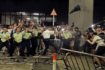 Polizisten setzen Pfefferspray gegen Demonstranten ein, die an dem Protest gegen das von der Regierung geplante Auslieferungsgesetz teilnehmen.