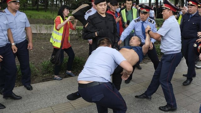 Die kasachische Polizei verhaftet einen Demonstranten bei einem Protest gegen die Präsidentschaftswahlen. Die kasachische Polizei verhaftet einen Demonstranten bei einem Protest gegen die Präsidentschaftswahlen.