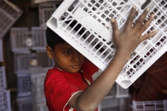 Ein zehnjähriger Junge arbeitet in einer Fabrik in Bangladesch: In vielen Ländern gehen Kinder arbeiten, um ihre Familie finanziell zu unterstützen.