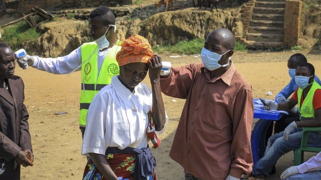 Am Grenzübergang Kasindi zwischen dem Kongo und Uganda wird die Körpertemperatur von Passanten gemessen. Am Grenzübergang Kasindi zwischen dem Kongo und Uganda wird die Körpertemperatur von Passanten gemessen.