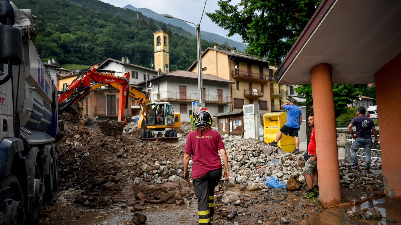 Überschwemmungen in Norditalien: Eine Feuerwehrfrau geht eine überschwemmte Straße entlang