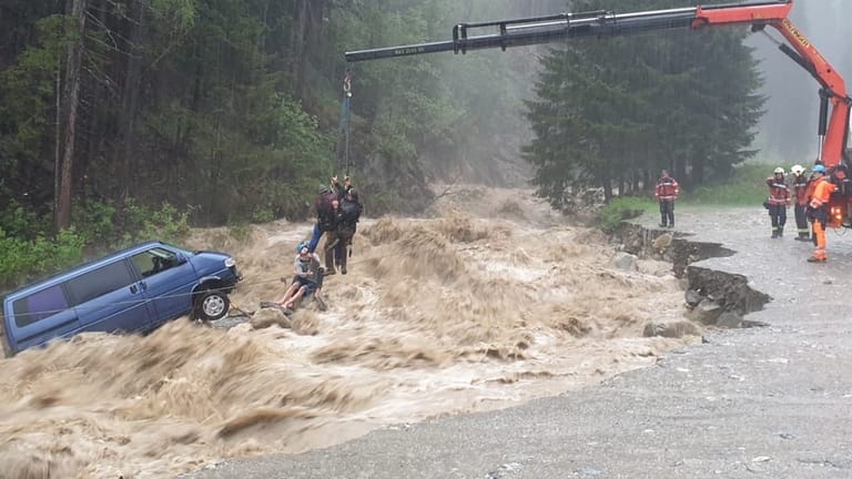 Krank rettet Touristen aus reißendem Fluss: Zwei Deutsche hatten in der Schweiz Glück im Unglück – Rettungskräfte mussten sie aus ihrem Auto heben.