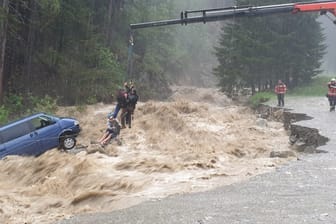 Krank rettet Touristen aus reißendem Fluss: Zwei Deutsche hatten in der Schweiz Glück im Unglück – Rettungskräfte mussten sie aus ihrem Auto heben.