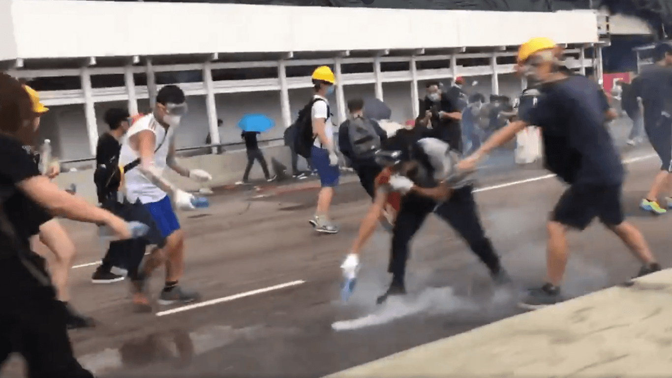 Wie ein Formel-1-Team in der Boxengasse: Mehrere Demonstranten stürzen sich auf ein Tränengas-Geschoss und machen es unschädlich