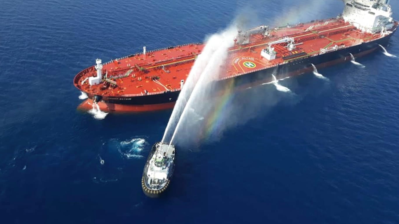 Ein iranisches Marineboot spritzt Wasser, um ein Feuer auf einem Öltanker im Meer des Oman zu löschen.