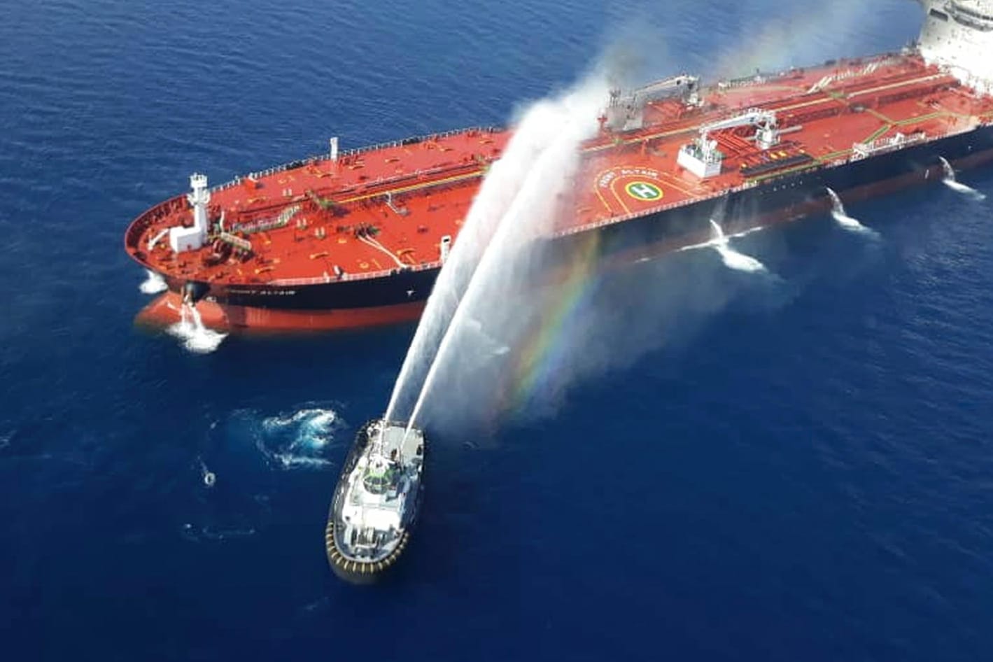 Ein iranisches Marineboot spritzt Wasser, um ein Feuer auf einem Öltanker im Meer des Oman zu löschen.