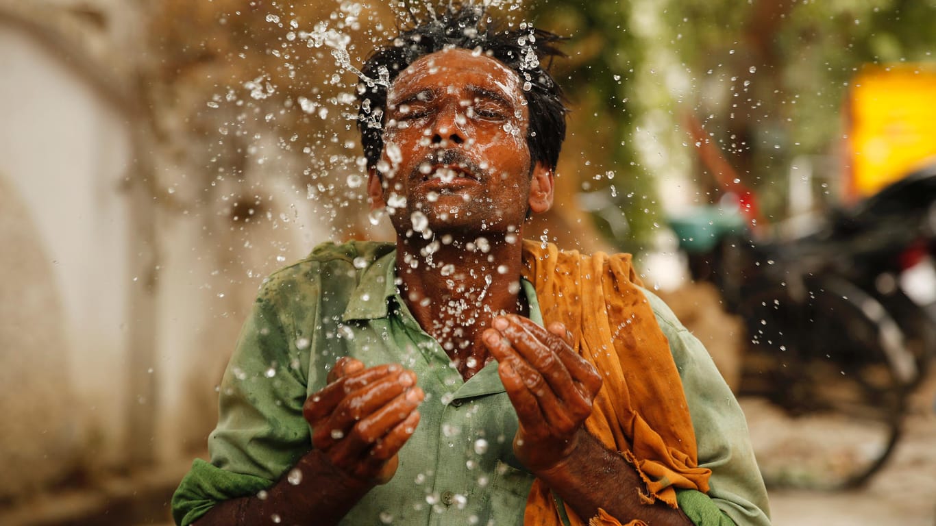 Ein indischer Arbeiter spritzt sich Wasser ins Gesicht: Seit Tagen ist es in Indien und Pakistan deutlich heißer als 40 Grad Celsius.