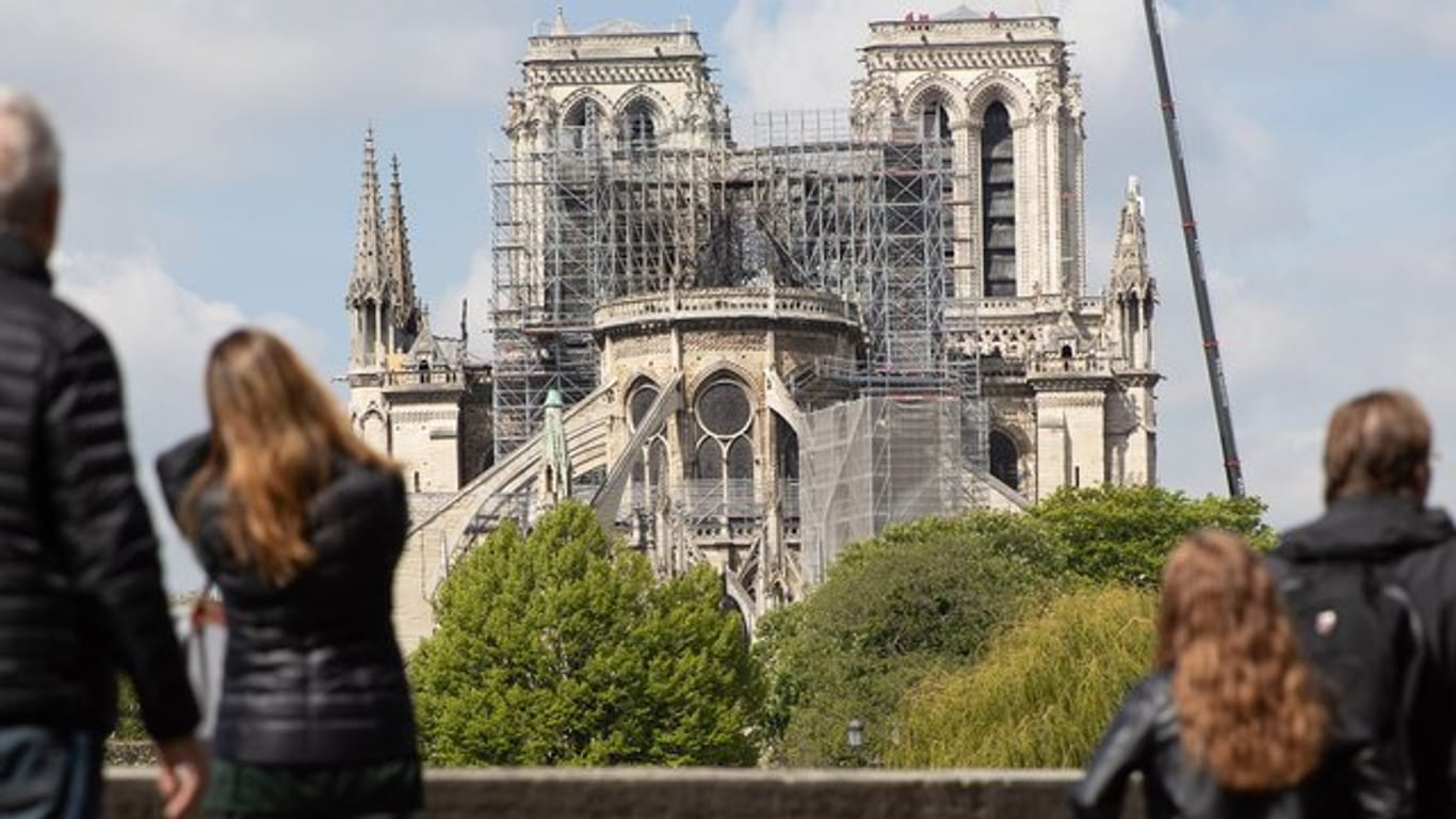 Ein Kran steht neben der schwer beschädigten Pariser Kathedrale Notre-Dame.