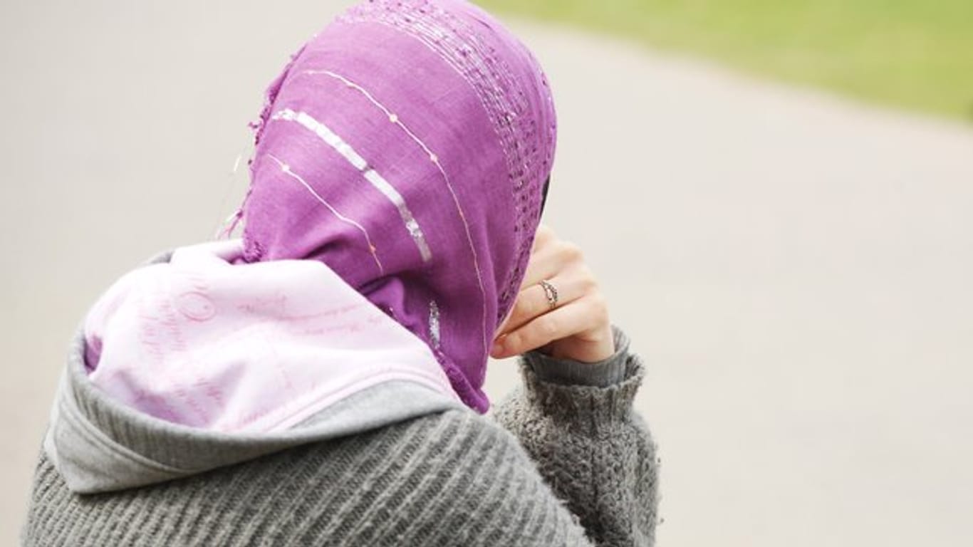 Eine junge Muslimin trägt ein Kopftuch zu einem modernen, westlichen Kapuzenpullover.