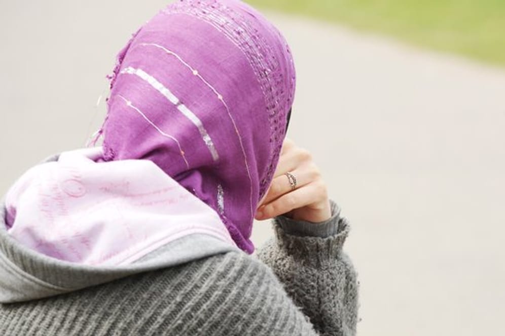 Eine junge Muslimin trägt ein Kopftuch zu einem modernen, westlichen Kapuzenpullover.