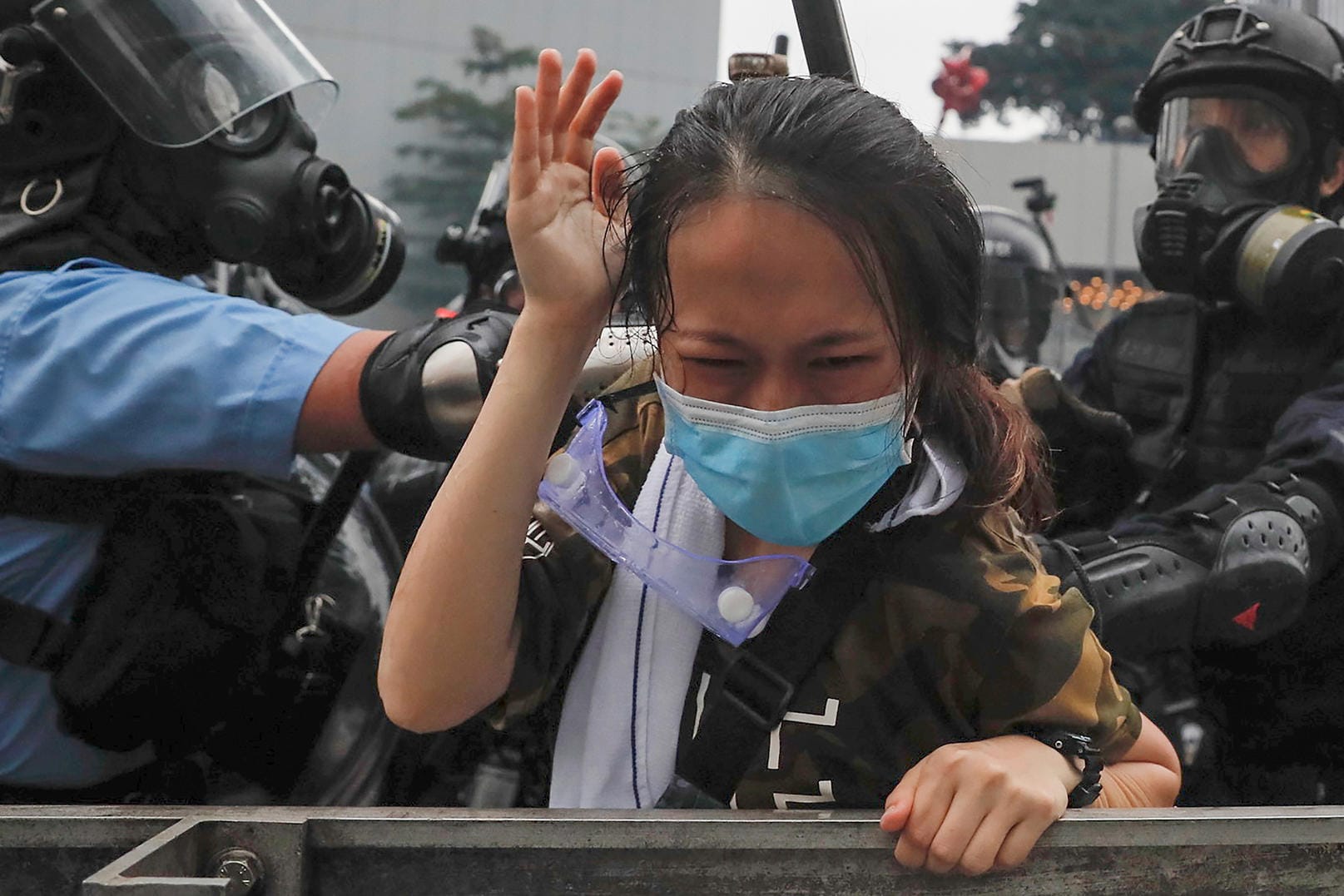 Polizisten drücken eine Demonstrantin gegen eine Absperrung. Bei neuen Protesten in Hongkong gegen das kontroverse Gesetz für Auslieferungen nach China ist es zu schweren Zusammenstößen mit der Polizei gekommen.