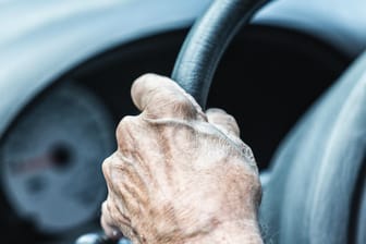 Elderly Senior Man Driver Hand Gripping Car Steering Wheel Close-Up