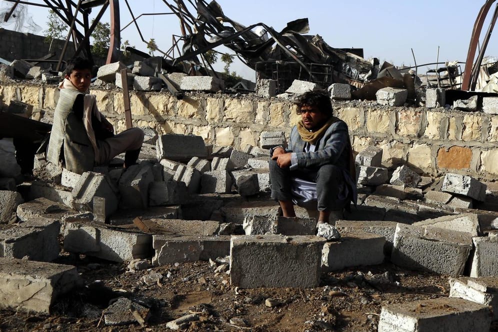 Ein Mann sitzt im Jemen vor den Trümmern seines Hauses, das durch einen Luftangriff zerstört wurde.