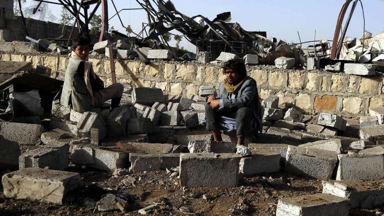 Ein Mann sitzt im Jemen vor den Trümmern seines Hauses, das durch einen Luftangriff zerstört wurde.
