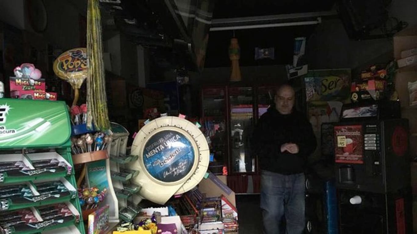 Ein Händler steht während des Stromausfalls in seinem dunklen Laden in Buenos Aires.