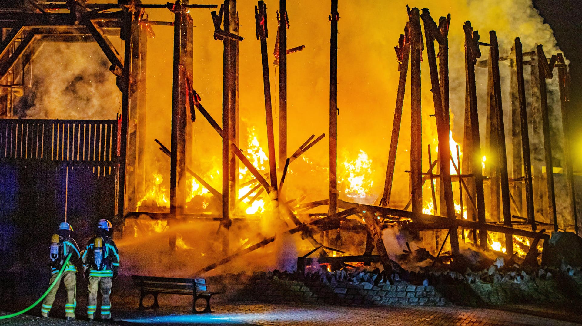 Feuerwehrleute halten einen Schlauch auf die meterhohen Flammen: Verletzt wurde bei dem Brand der Duisburger Therme niemand.