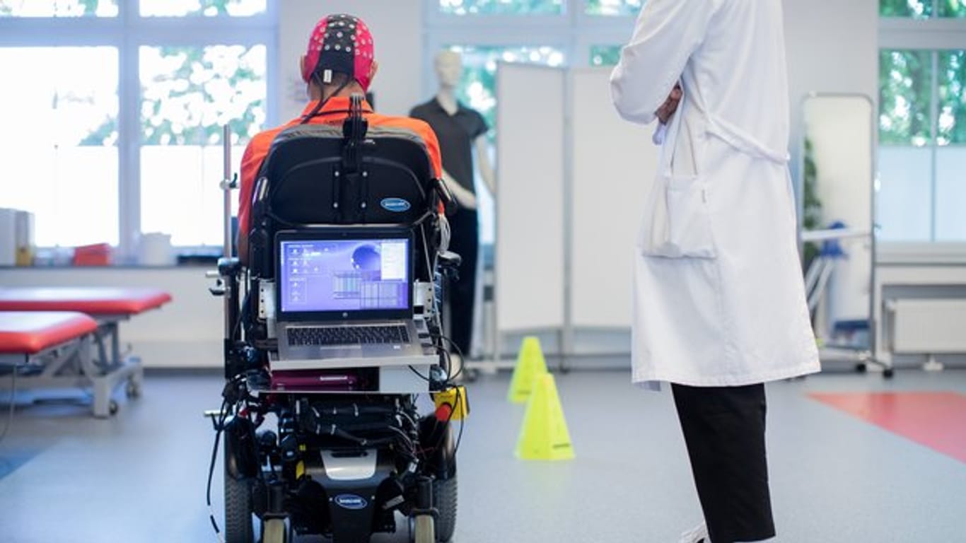 Sarshar Manoucheher, ein querschnittsgelähmter Patient, fährt mit seinen Rollstuhl durch einen Parcours, gesteuert mittels einer Hirn-Computer-Schnittstelle durch Gedankenkraft.